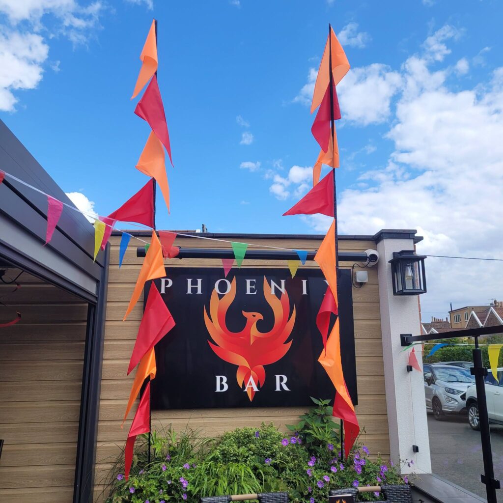 The Phoenix Bar sign with festival flags