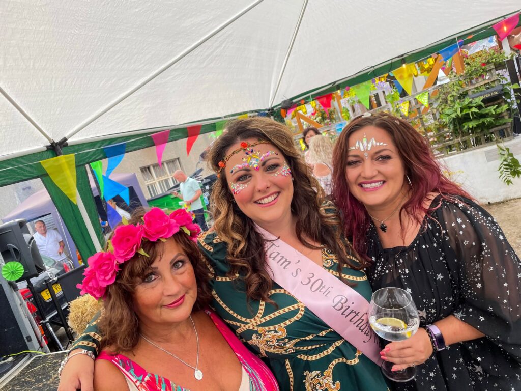 Friends in festival face gems celebrating a 30th birthday in the beer garden