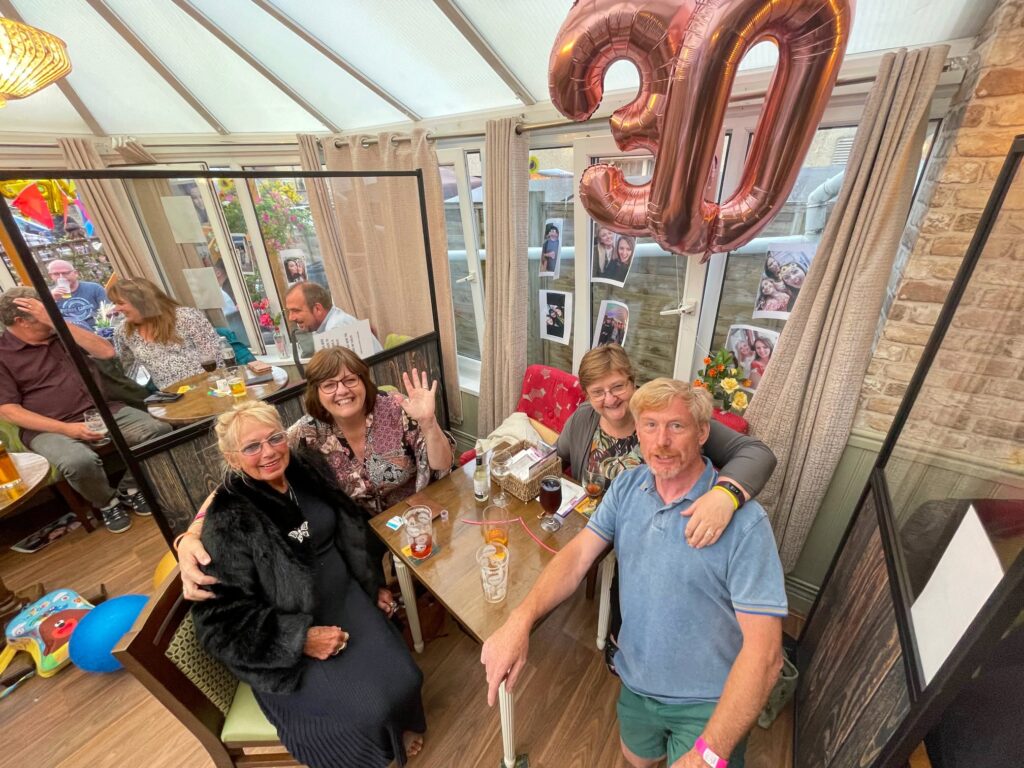 A table of friends celebrating a 30th birthday in the conservatory