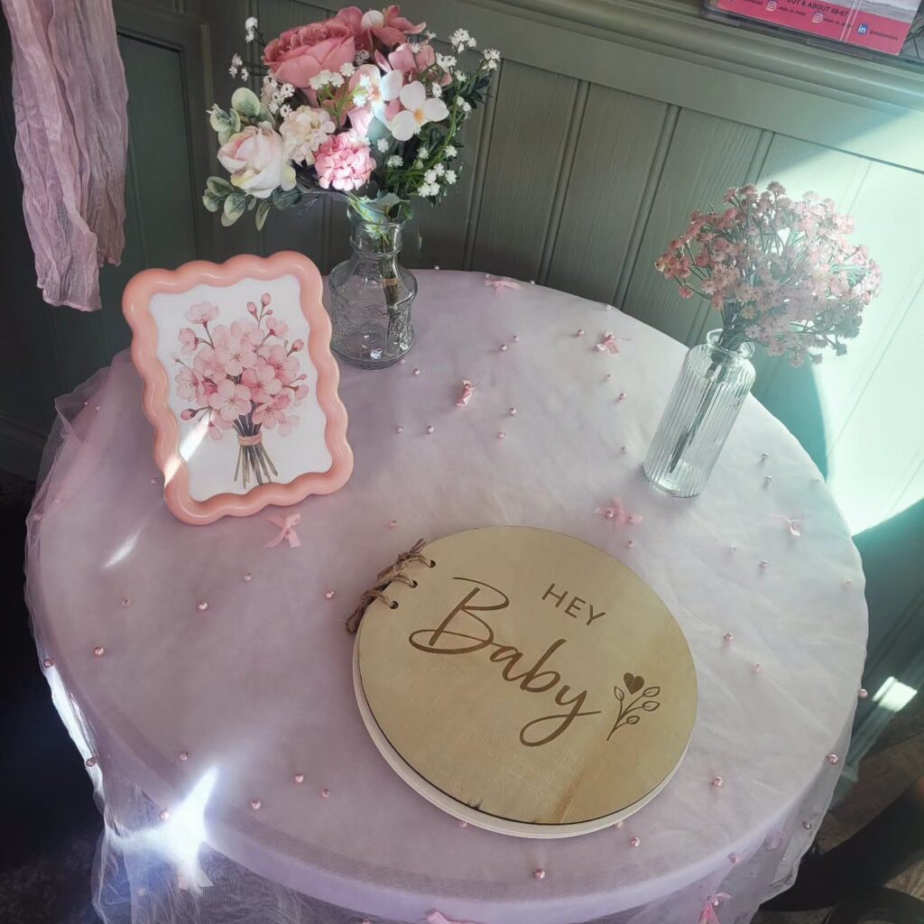 Baby shower guest book table with pink flowers